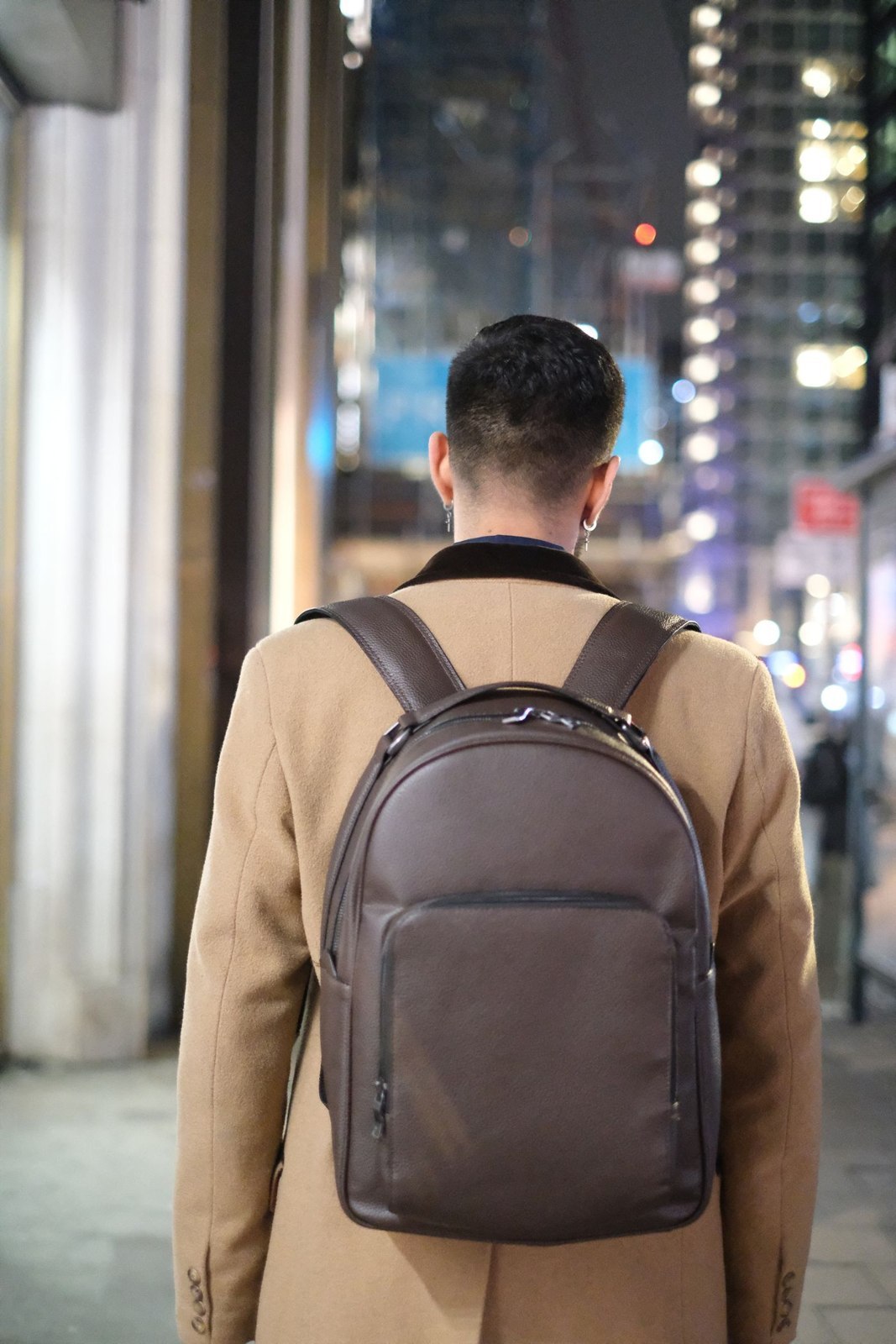Kompakter Rucksack über einem beigen Mantel