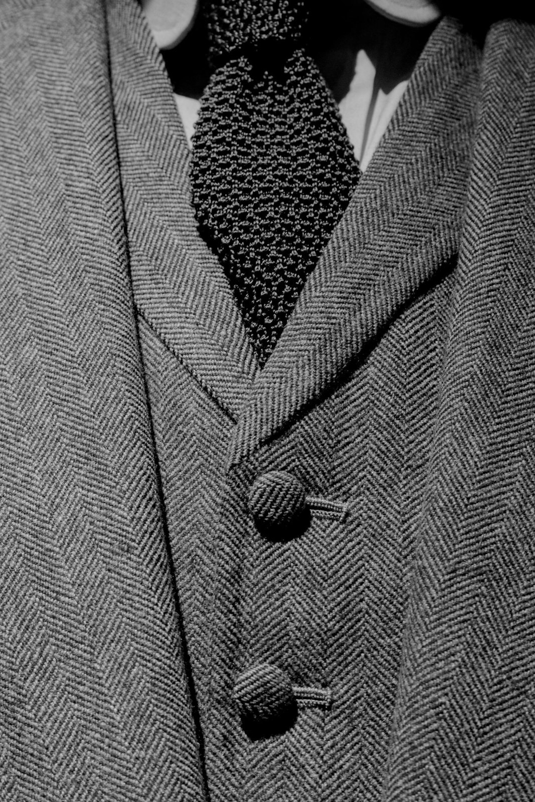 Eine Strickkrawatte an einem strukturierten Sakko