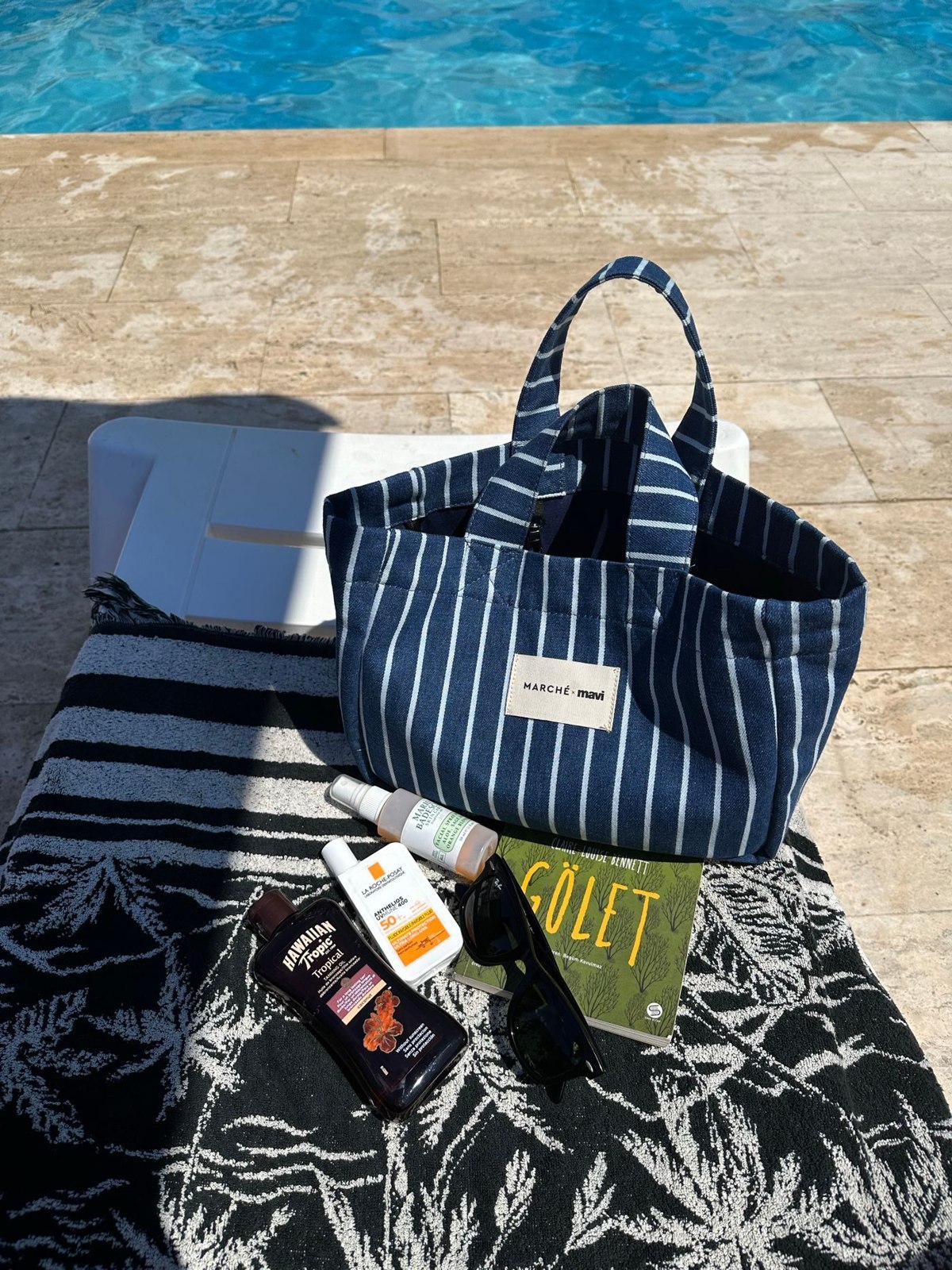Gestreifte Badetasche mit Handtüchern und Zubehör