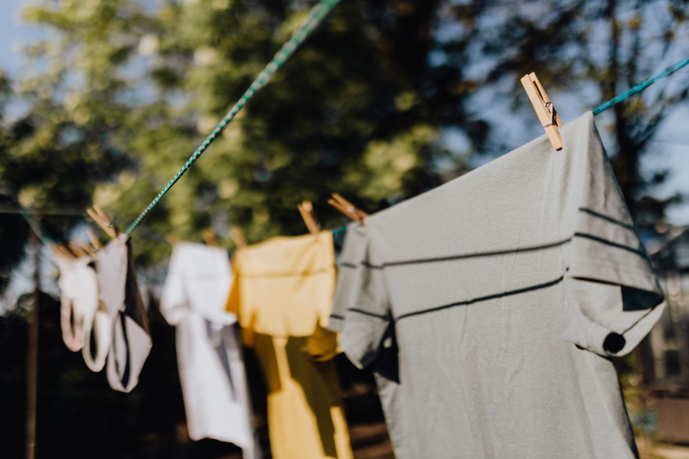Hemden und Shirts trocknen draußen auf einer Wäscheleine