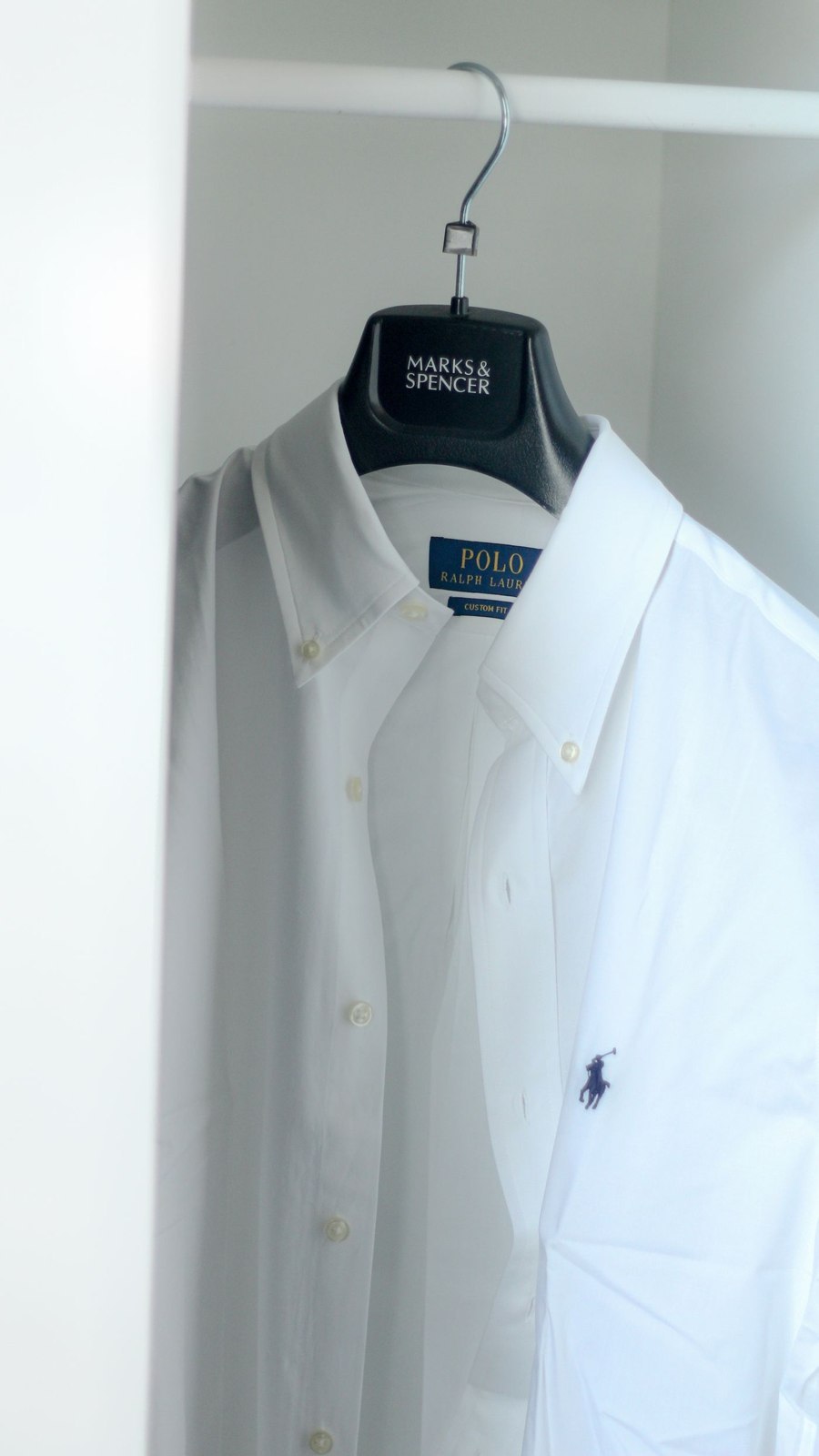 Weißes Button-down-Hemd auf einem Bügel