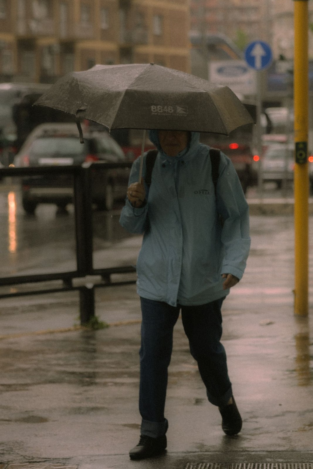 Mantel und Regenschirm auf einer regnerischen Straße